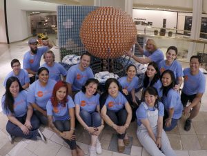 Architects Orange members pose in front of their sculpture Rising Above Hunger built for the Canstruction charity fundraiser.